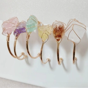 Detail of diverse raw natural crystal stone bracelets with gold wire wrapped frames