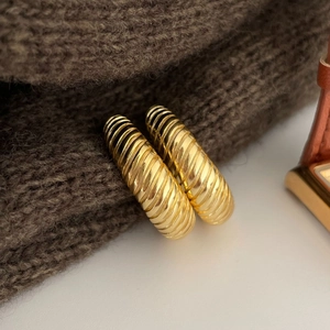 French vintage gold twist textured hoop earrings displayed on a cozy knit fabric background
