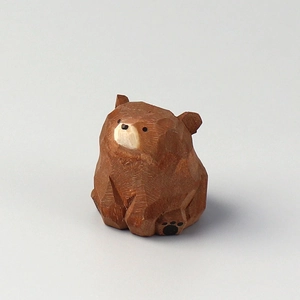 Handcrafted brown wooden bear figurine with detailed carved texture on white background