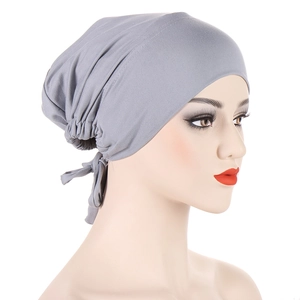 Detail of dark grey satin-lined turban cap featuring adjustable back drawstring straps