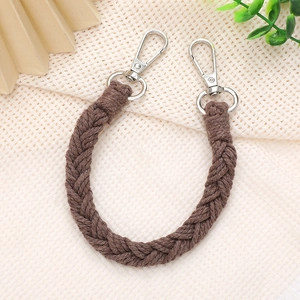 Detail of a brown hand-woven cotton strap with silver metal lobster clasps for bags