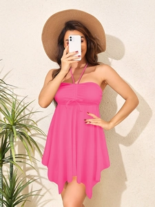 Detail of hot pink halter swim dress featuring ruched drawstring and ruffled hemline
