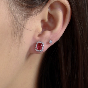 Vintage emerald-cut red gemstone earrings with diamond halo shown worn by a model
