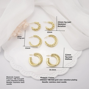 Detail shot of hollow twisted C-shape earrings in 18k gold plating on elegant fabric