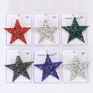 Star-shaped rhinestone brooches in six colors including red, blue and green on white cards