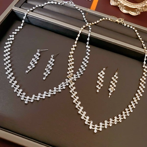 Detail of silver and gold geometric jewelry sets with sparkling zircon inlays on a tray