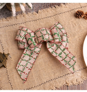 Detailed view of Christmas burlap bow with pine needle pattern on rustic linen background