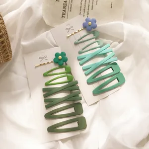 Haarklammern Set in Avocadogrün mit matten Blumen und Wellenmotiven auf Displaykarte