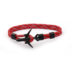 Detailed view of red, blue and white braided paracord bracelet with a black airplane charm