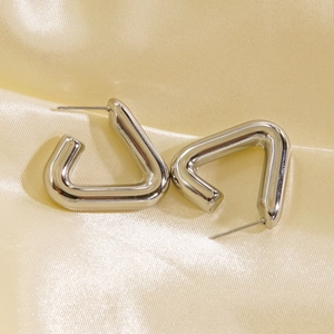 Polished silver triangle titanium steel earrings on a soft silk fabric background