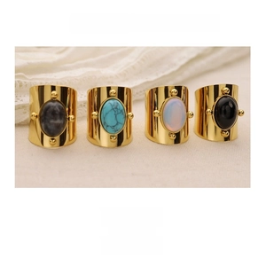 Detailed view of four vintage gold-plated wide rings with diverse oval gemstones set in a row