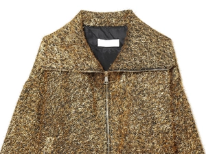 Close-up of golden metallic fiber texture and zipper detail on French bomber jacket