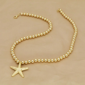 Golden beaded necklace featuring a starfish pendant with starfish texture for summer beach style
