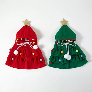 Detailed flat lay of red and green knitted Christmas tree dog cloaks with festive pom-poms