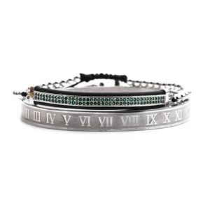 Détail du jonc argenté à chiffres romains et bracelet en perles de zircon vert sur fond blanc
