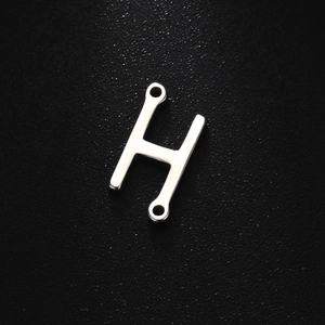 Detailed view of silver stainless steel H-letter pendant with double hanging loops