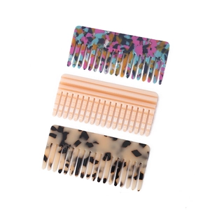 Flat lay of three acetate hair combs in floral, striped, and tortoiseshell patterns