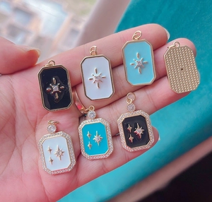 Macro shot showing small rectangular enamel North Star pendants in various colors