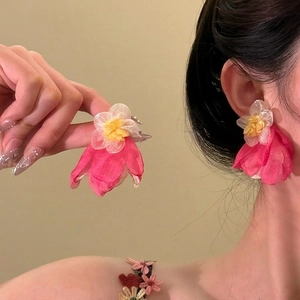 Detailed close-up of handmade pink fabric flower earrings worn to show style and size