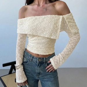 Close-up of beige off-the-shoulder top with flared sleeves and textured knit fabric