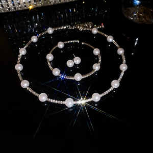 Close-up of elegant pearl and rhinestone jewelry set with necklace bracelet and earrings