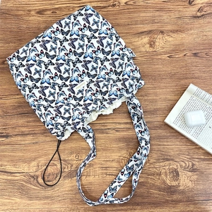 Detail of butterfly print canvas tote bag with drawstring closure and brand woven label