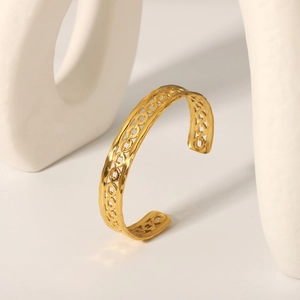 Macro detail of 18K gold plated hollow chain link bangle with polished metal finish