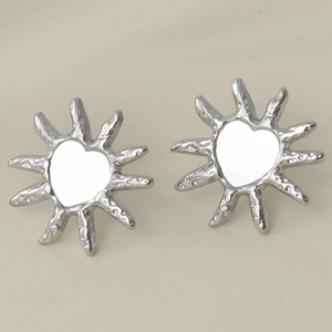 Detailed macro of silver heart sun stud earrings featuring hammered ray texture finish