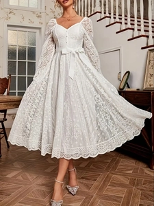 Détails de la dentelle florale, du décolleté en V et du nœud sur cette robe vintage blanche
