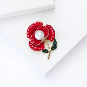 Elegant red enamel pansy flower brooch with green crystals and pearl on a white stand