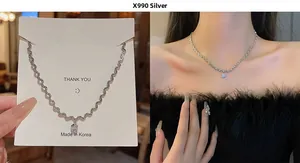 Detail of silver bow pendant necklace with zircon stone on model and card