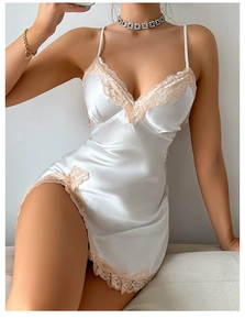 Detail of silk satin nightgown featuring peach lace trim and side slit in pearl white