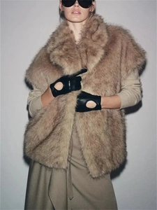 Gros plan sur le gilet en fausse fourrure marron clair avec large revers et texture épaisse
