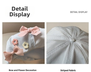 Detail view of light blue beret featuring pink bow, floral accents and striped texture