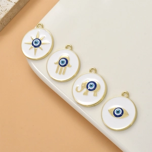 Set of four gold-plated evil eye charms with sun, elephant, and hand of hamsa motifs