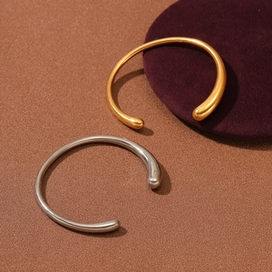 Minimalist stainless steel open bangle with teardrop ends in gold and silver finish