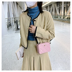 Fashionable pink PVC jelly bag with quilted texture and chain strap worn by a girl