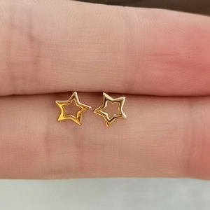 S925 sterling silver hollow star stud earrings in gold finish shown on finger