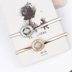 Détail de ceintures chaîne élastiques en métal avec boucles rondes ornées de strass