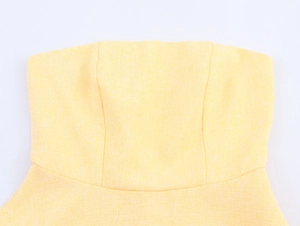 Dettaglio del top a fascia giallo pallido con trama in lino e cuciture rifinite