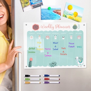 Macro shot of magnetic acrylic weekly planner on fridge with colorful markers and meal plans