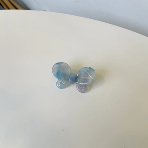 Close-up of light blue and purple marble bow hair clip with sparkling rhinestones