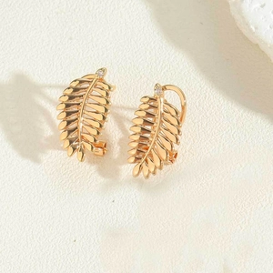 Close-up of 14K gold plated leaf earrings featuring a delicate clear crystal stud detail