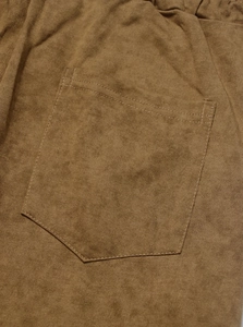 Detail of the brown washed cotton pants featuring reinforced double-stitched back pockets