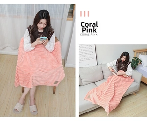 Detailed view of coral pink flannel fleece blanket with vertical ribbed texture