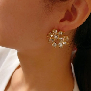 Vintage style geometric hollow gold earrings with sparkling zircon crystals worn by a model