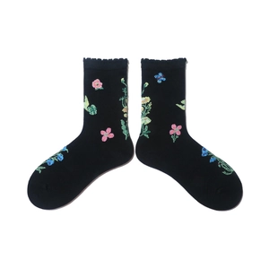 Detail of black cotton socks featuring floral and butterfly embroidery with lace trim edges