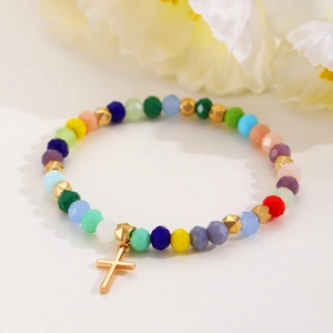 Detail of colorful faceted crystal beads bracelet with a gold cross metal pendant charm