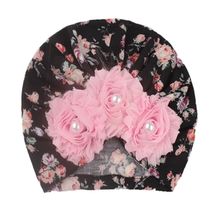 Floral print baby turban hat in black with three pink chiffon flowers and pearl center