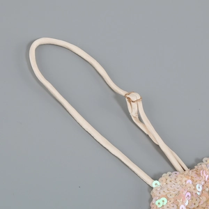 Detail of adjustable gold strap on a champagne sequin evening dress with metallic buckle